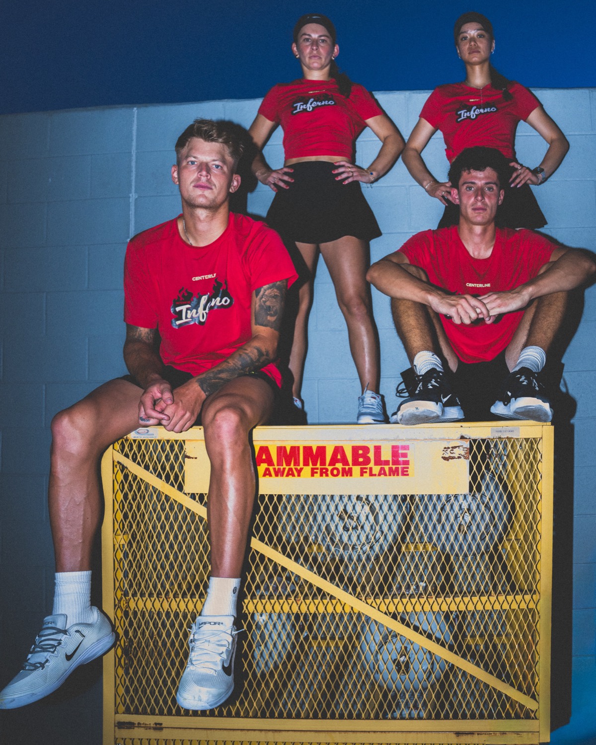 Four Inferno players sitting on a yellow flammable-gas cage